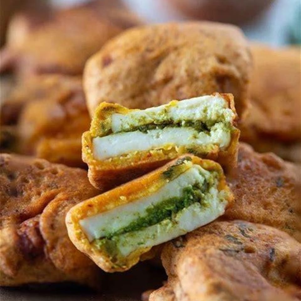 Close-up of Mirch Masala Town's paneer pakora, featuring a green chutney filling between two paneer slices.